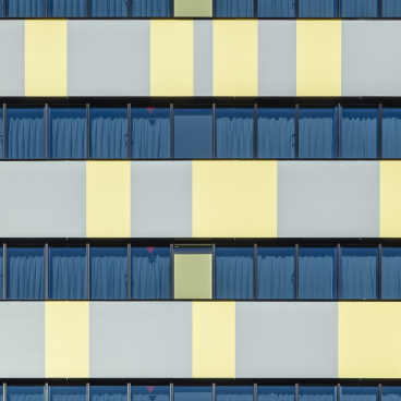 Colorful façade of Toggle Hotel Tokyo, showcasing modern architectural design with blue curtains and vibrant geometric patterns.