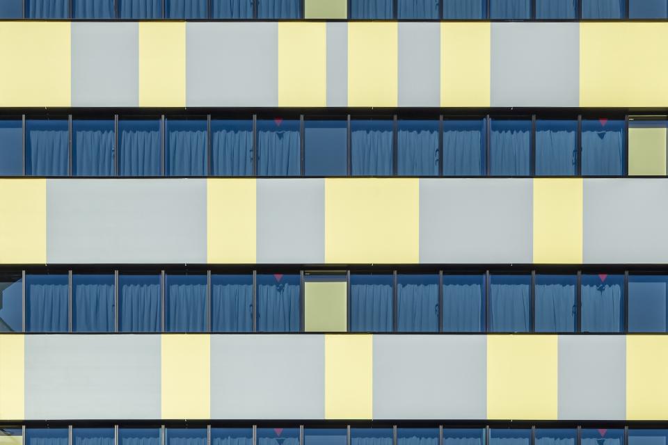 Colorful façade of Toggle Hotel Tokyo, showcasing modern architectural design with blue curtains and vibrant geometric patterns.