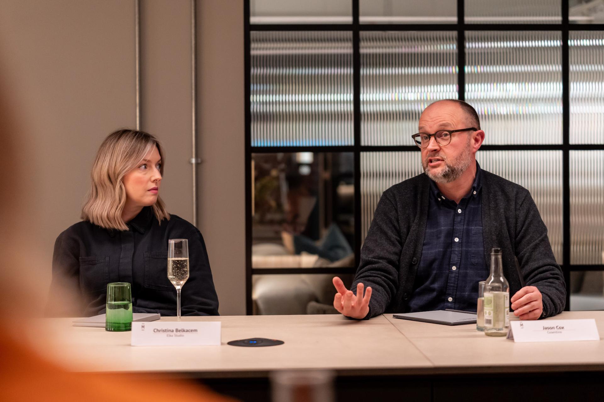 Participants engage in a roundtable discussion focused on sustainability and value engineering strategies in a modern setting.
