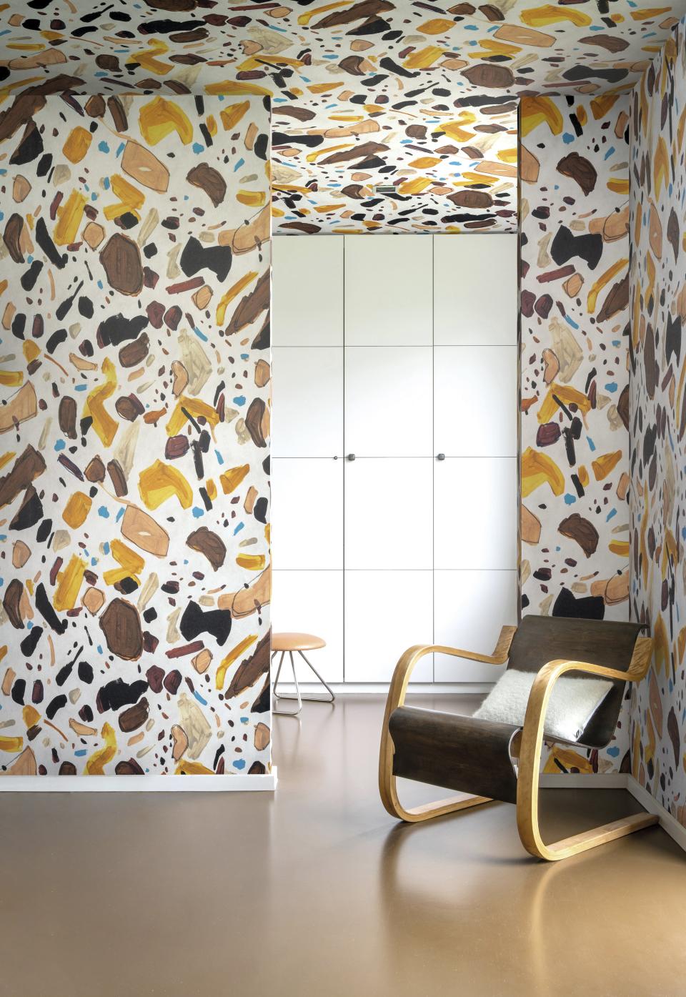 Stylish interior featuring Omexo's eco-friendly wallcovering design with vibrant textures and a wooden chair for modern decor.