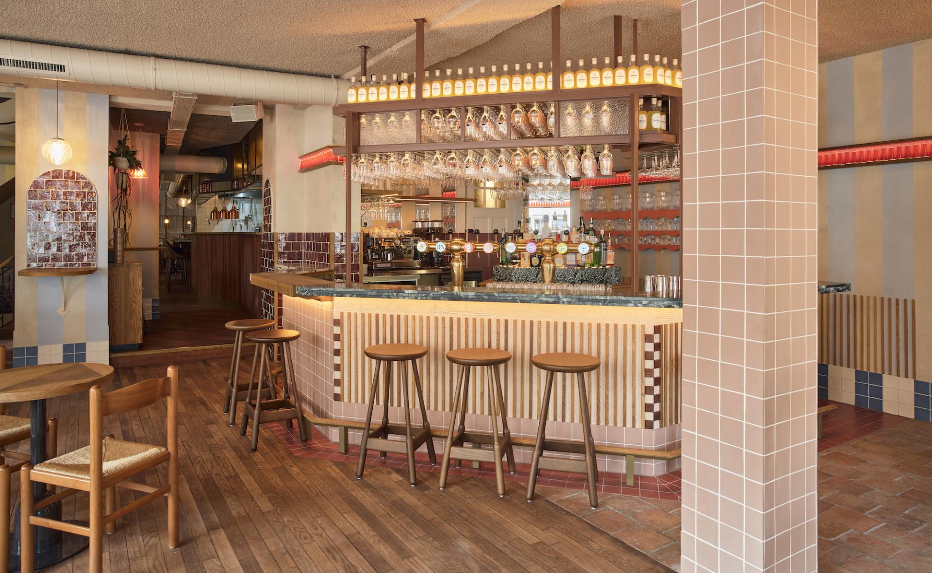 Stylish interior of Volare trattoria, featuring a wooden bar, colorful tiles, and a cozy atmosphere reminiscent of 1960s Amalfi Coast.