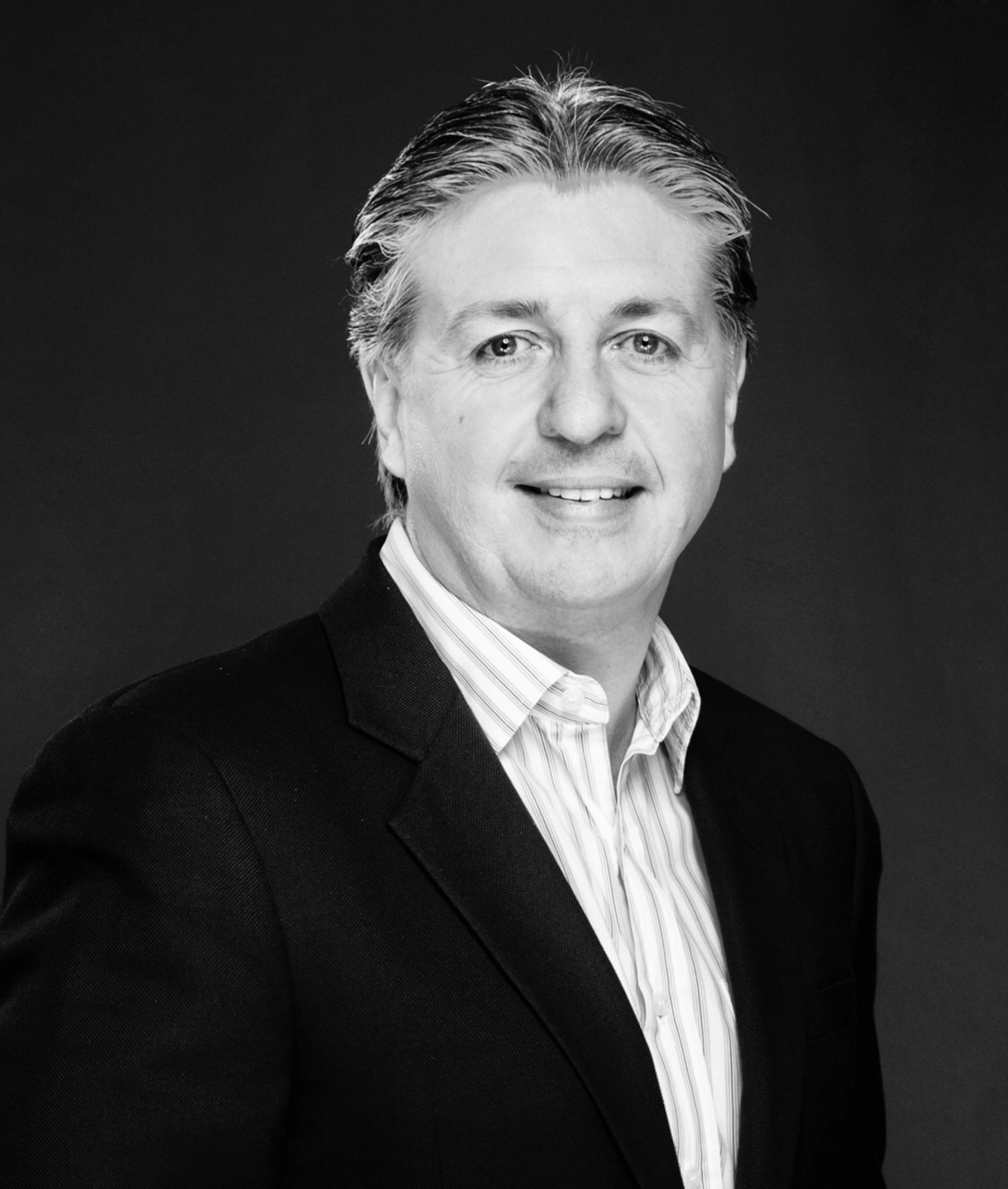 Professional portrait of a man in a suit, representing design leadership at Sanipex Gallery Dubai, UAE.