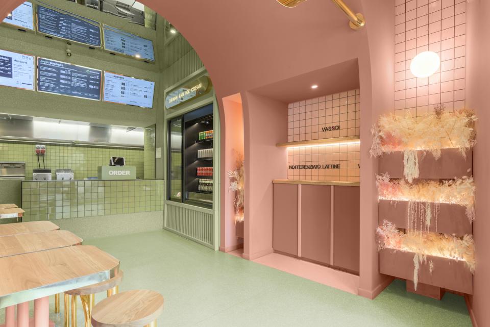 Modern interior of Masquespacio's Bun restaurant in Milan, showcasing colorful decor, menu boards, and stylish seating.