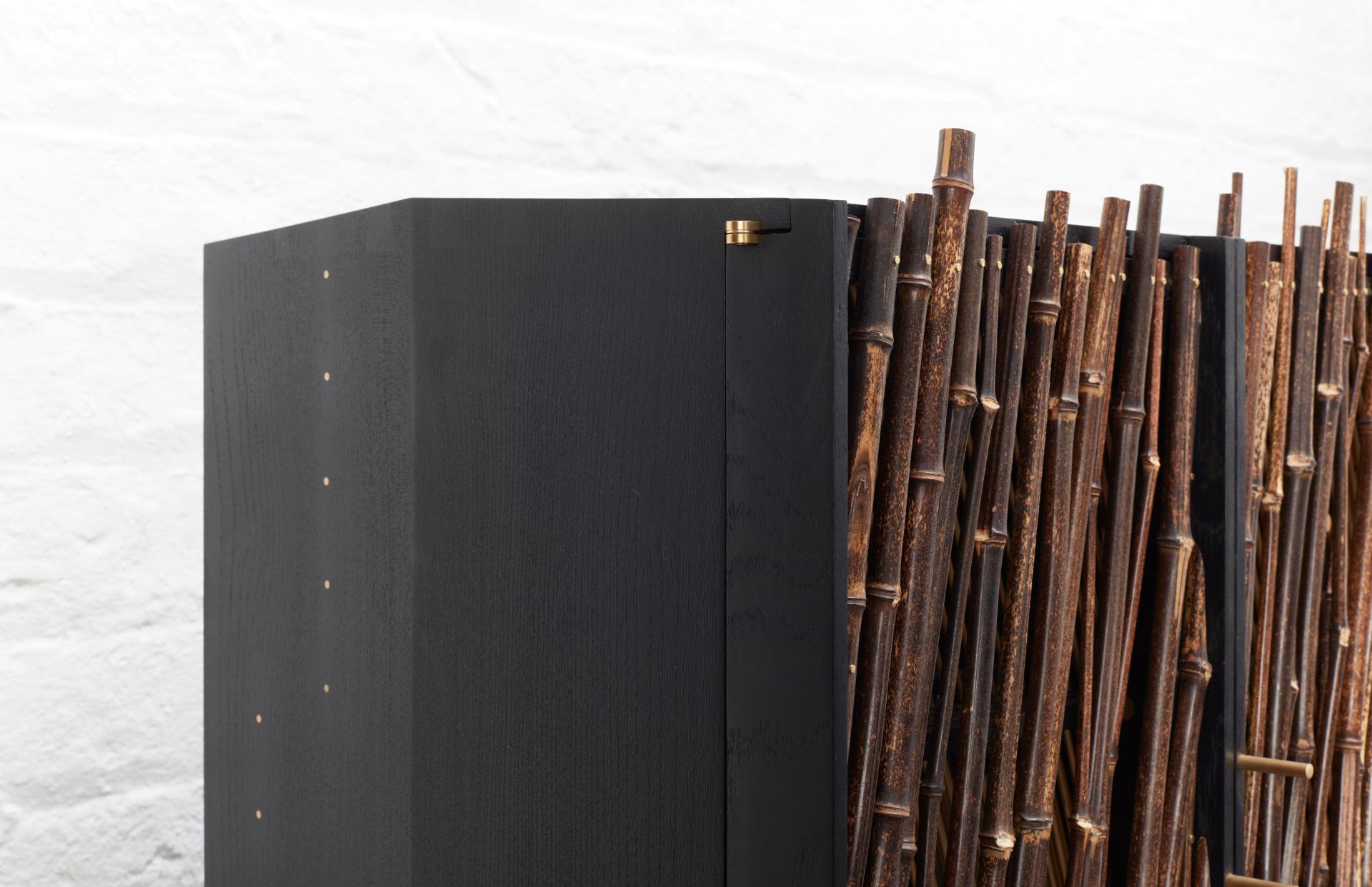 Japanese-inspired black drinks cabinet 'In Shadows' features textured bamboo accents, showcasing modern design aesthetics by Hugh Miller Furniture.