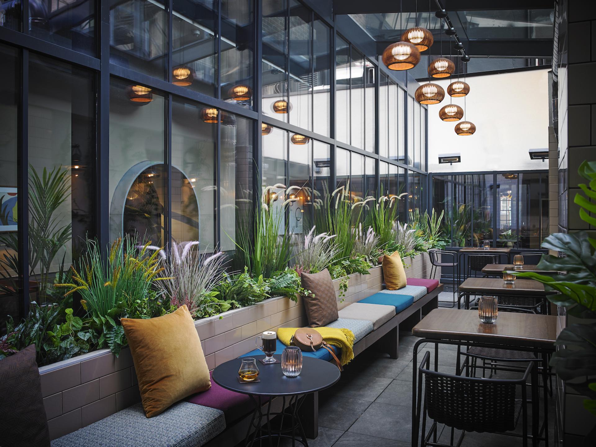Stylish indoor seating area at The Mont Hotel, featuring lush greenery, chic decor, and contemporary lighting.