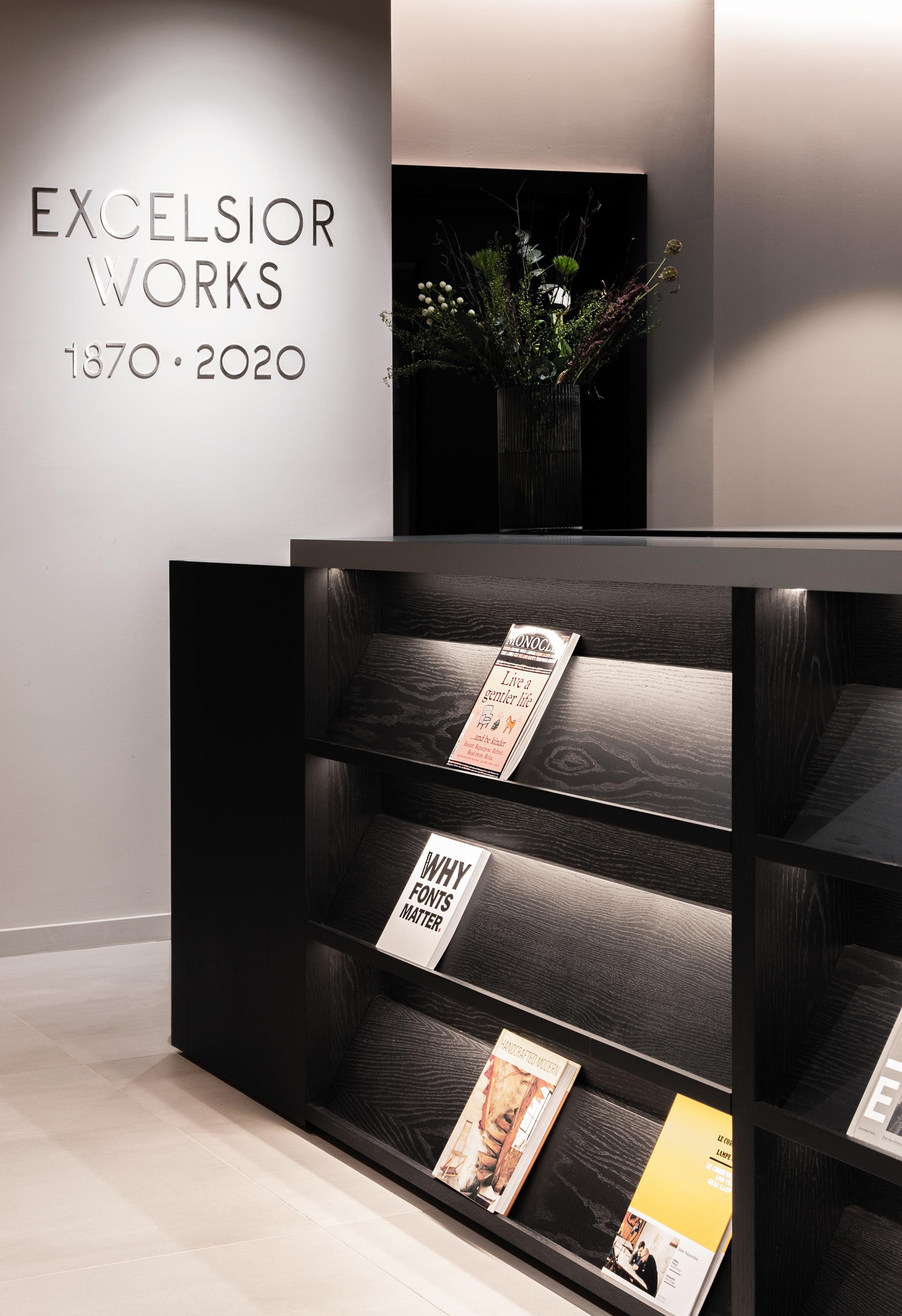 Excelsior Works display featuring contemporary books and a floral arrangement, merging modern design with historical significance in Manchester.