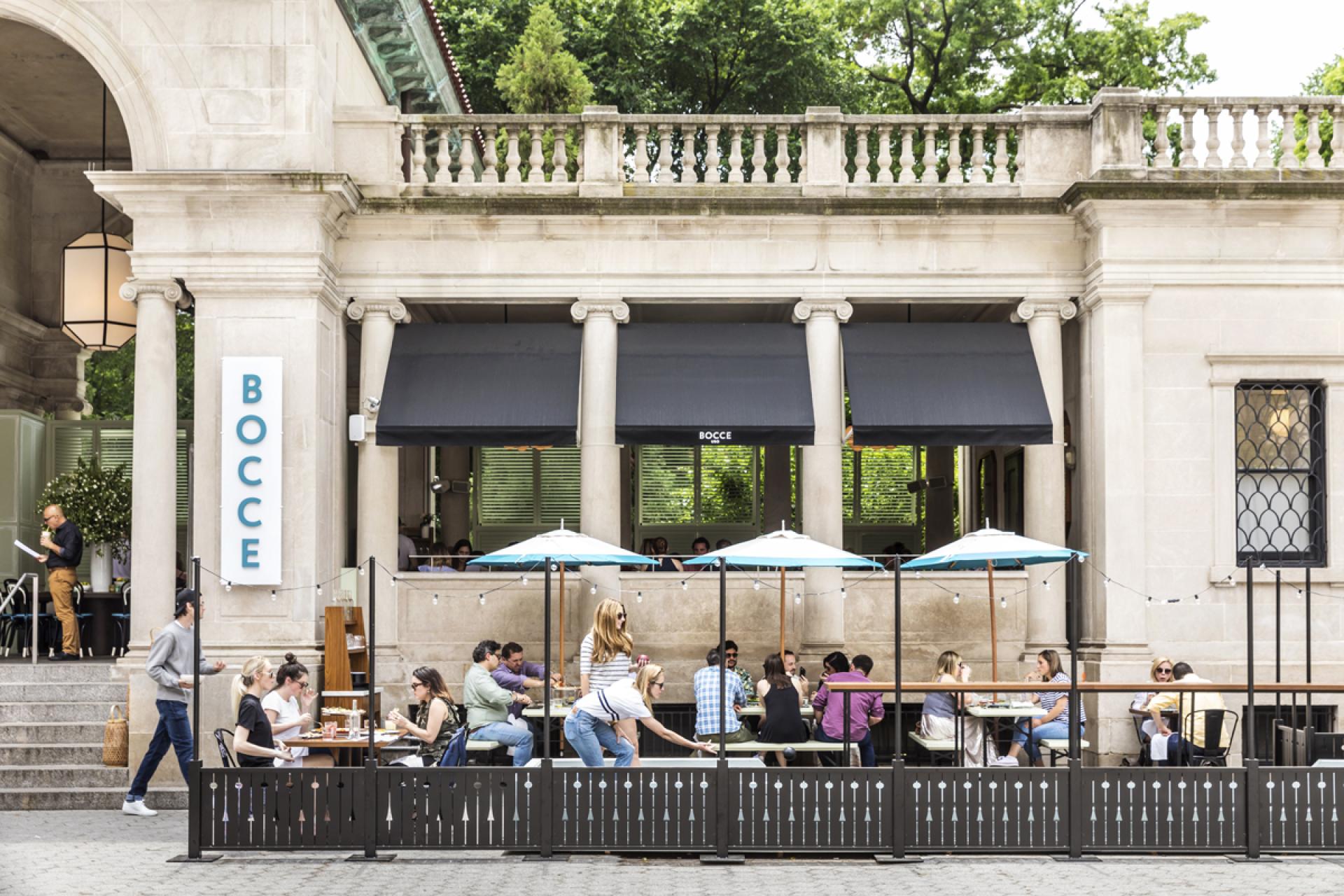 Outdoor dining at Bocce in Union Square, featuring modern decor, patrons at tables, and vibrant surroundings.