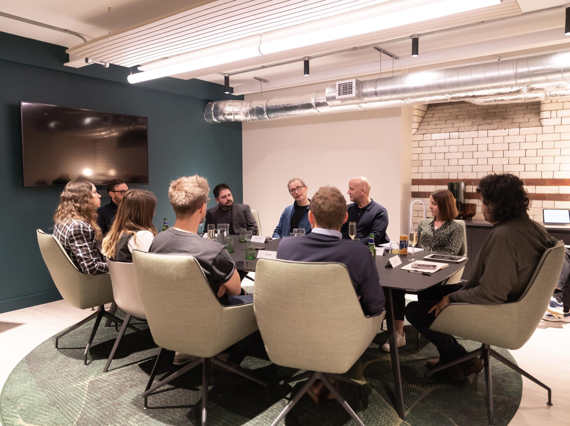 Group discussion in a modern office, focusing on technology's impact in the workplace after a seminar.