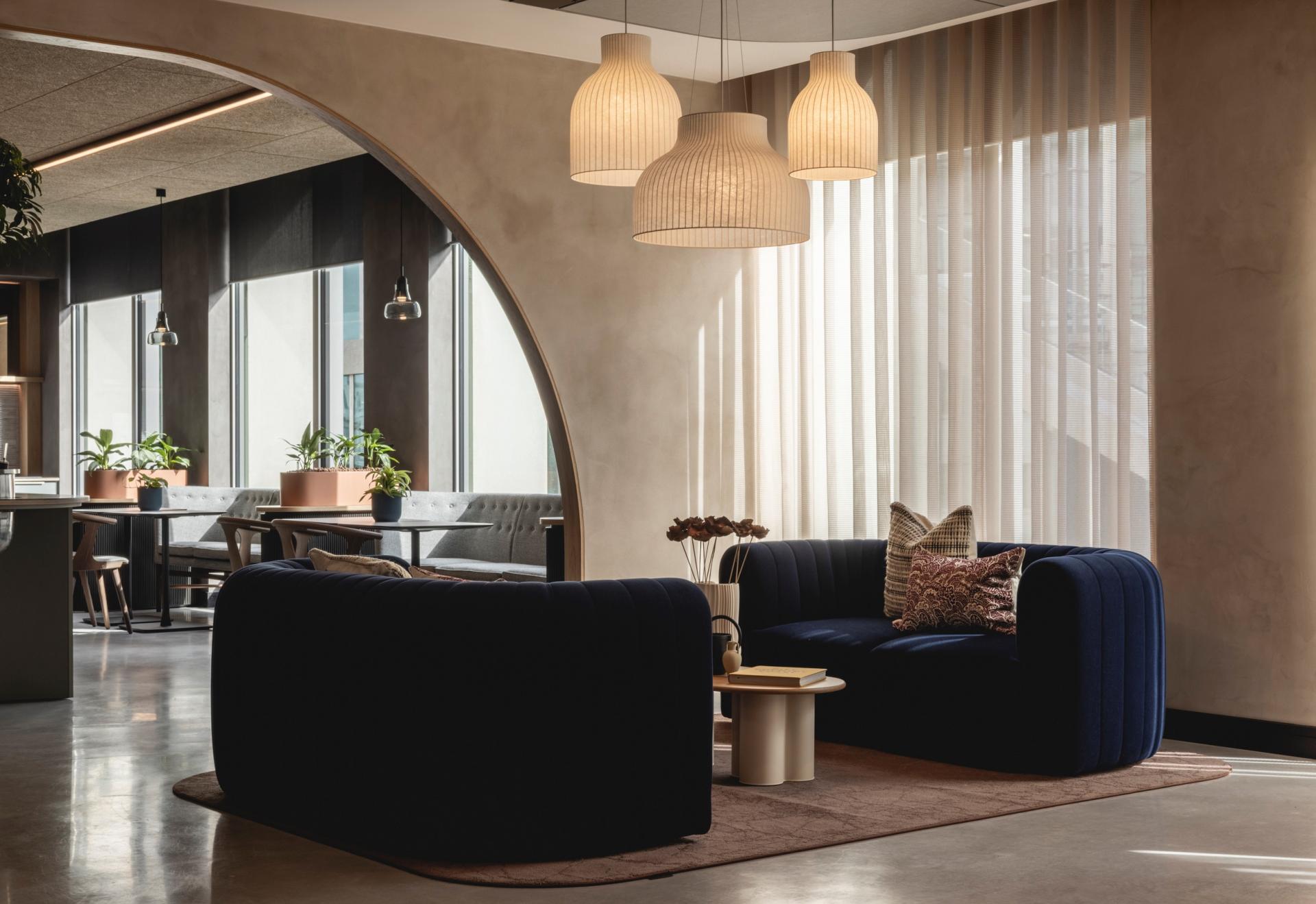 Stylish lounge area featuring Art Deco-inspired curves, plush seating, and a serene atmosphere in a contemporary workspace.