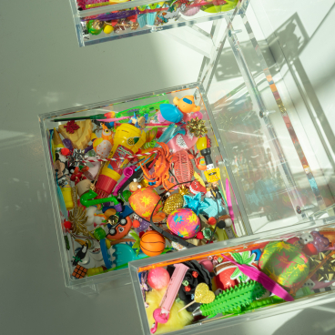 Colorful assortment of playful objects and design materials in transparent storage boxes, showcasing creativity and inspiration.