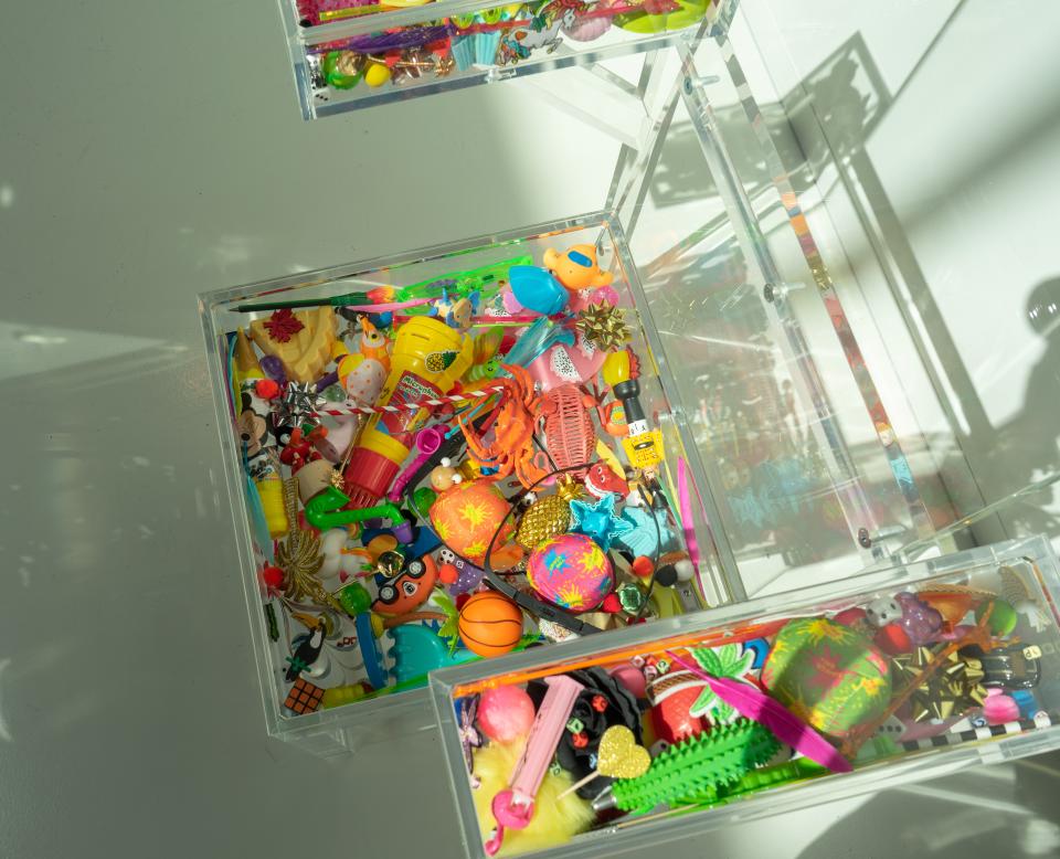 Colorful assortment of playful objects and design materials in transparent storage boxes, showcasing creativity and inspiration.