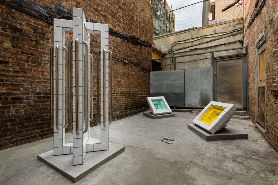 Sculptures by Zac Hacmon made from subway tiles displayed in an industrial space, showcasing architectural creativity.