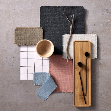 Sumi fabric swatches in various colors, alongside natural elements and decorative items on a textured surface.