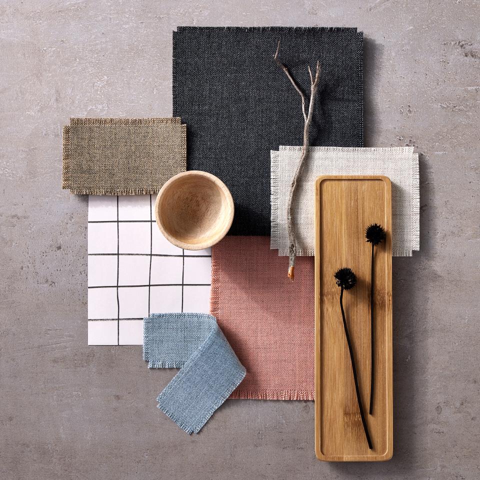 Sumi fabric swatches in various colors, alongside natural elements and decorative items on a textured surface.