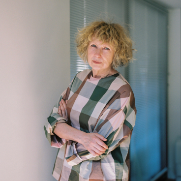Jennifer Newman, a furniture designer, poses confidently in a stylish, patterned blouse, showcasing her creative personality.