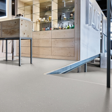 Modern adhesive-free safety flooring showcased in a sleek interior with wooden elements and display shelving.