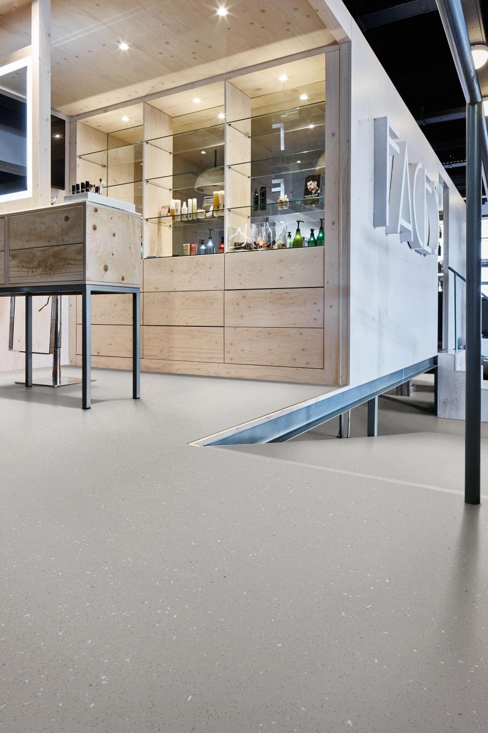 Modern adhesive-free safety flooring showcased in a sleek interior with wooden elements and display shelving.