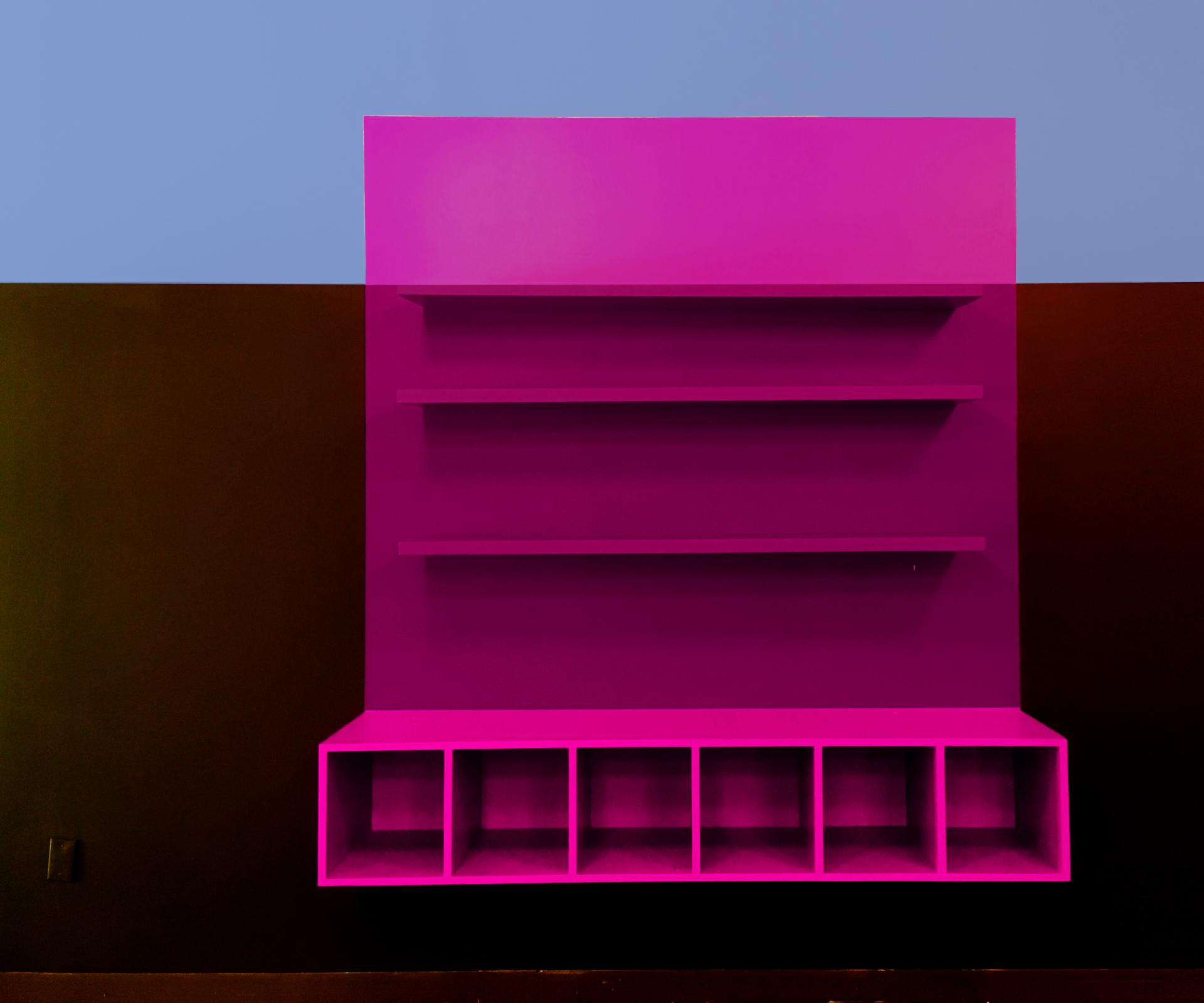 Bright pink shelving unit against a two-tone wall, designed for the ColorLab art space for children in Brooklyn.