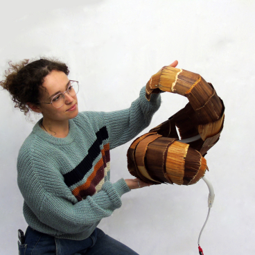 A designer showcases a unique, handmade lamp crafted from natural materials at the Surface Design Show.