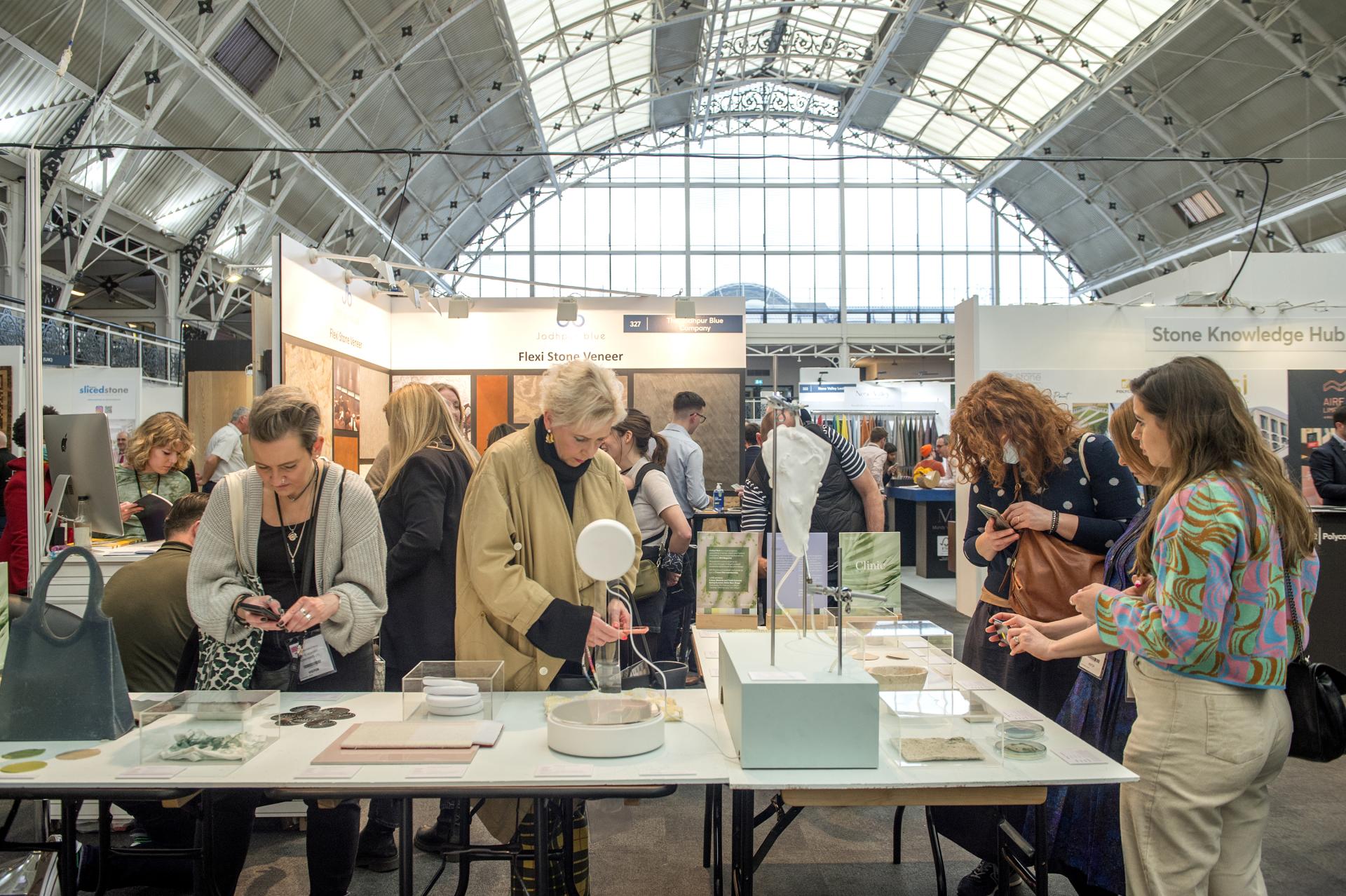 Visitors exploring innovative material displays at the Surface Design Show, highlighting Flexi Stone Veneer and sustainable design options.