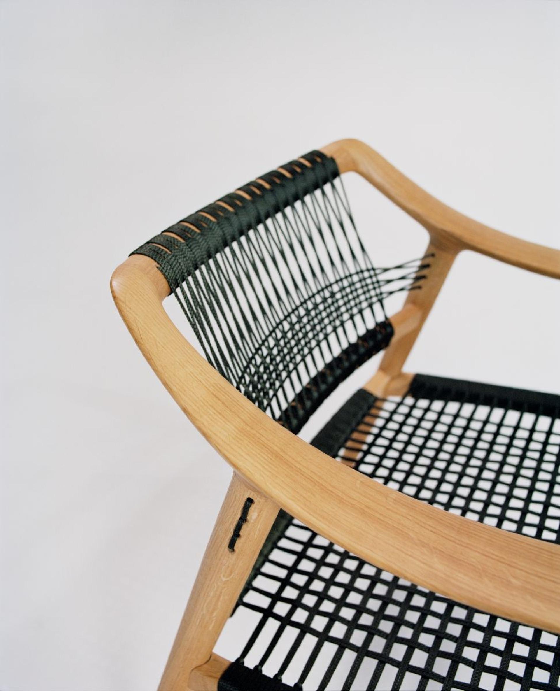 A contemporary wooden chair with a black woven seat, showcasing Norway's innovative approach to circular design in furniture.
