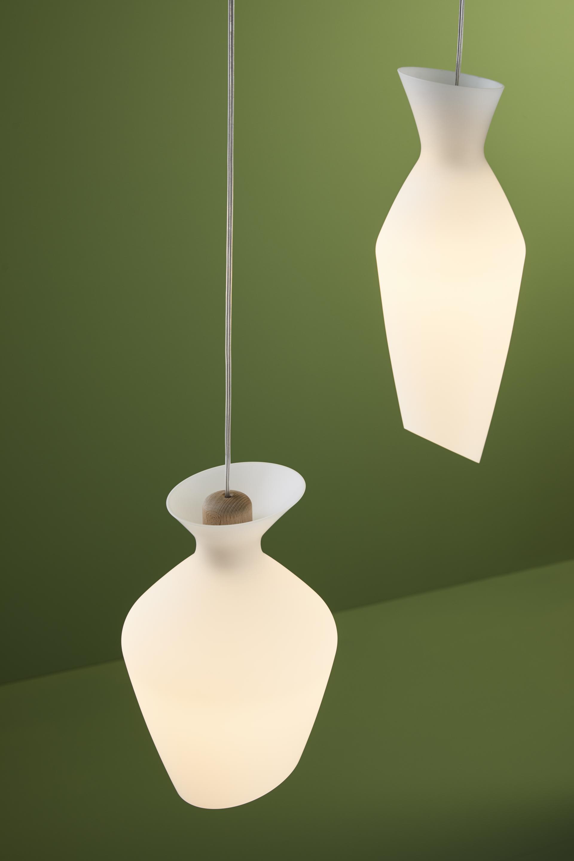 Elegant blown glass lamps by Fabbian feature rounded shapes and oblique edges, complementing modern interior aesthetics.