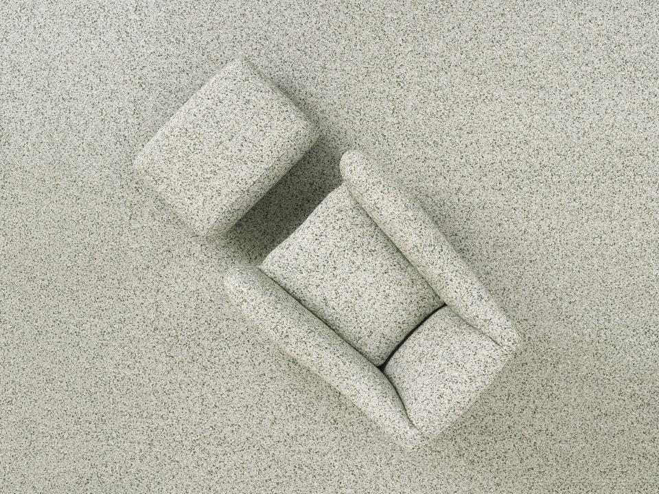 Balzac armchair by Matthew Hilton displayed on a textured gray surface, celebrating thirty years of design innovation.