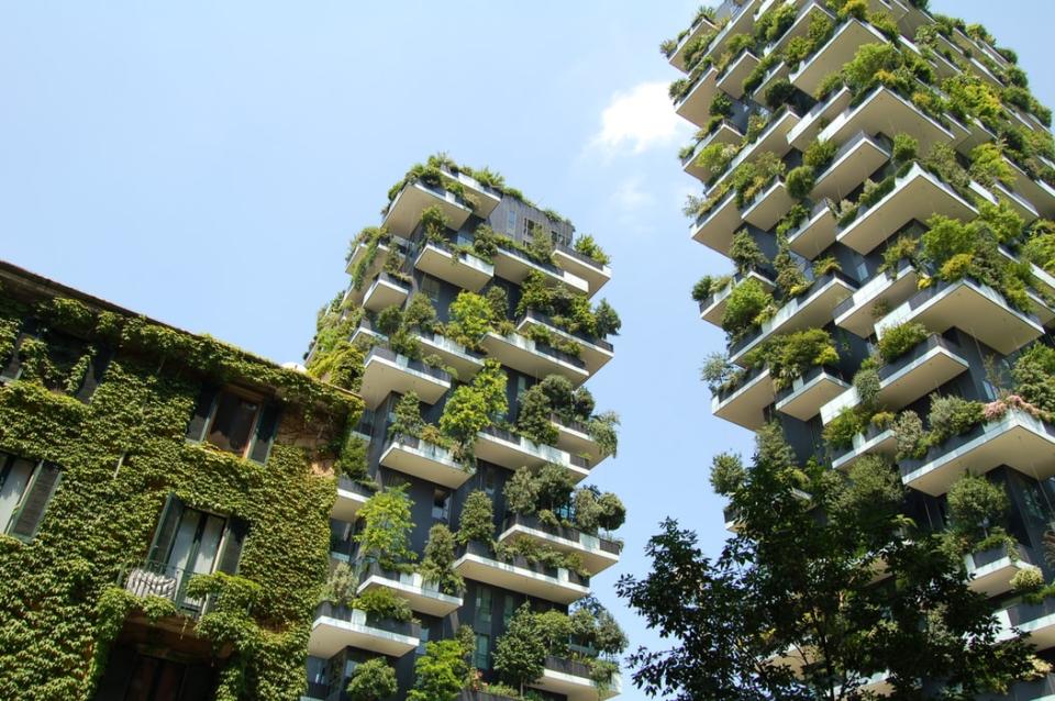 Contemporary green architecture featuring lush, vertical gardens on residential buildings, promoting urban sustainability and connection to nature.