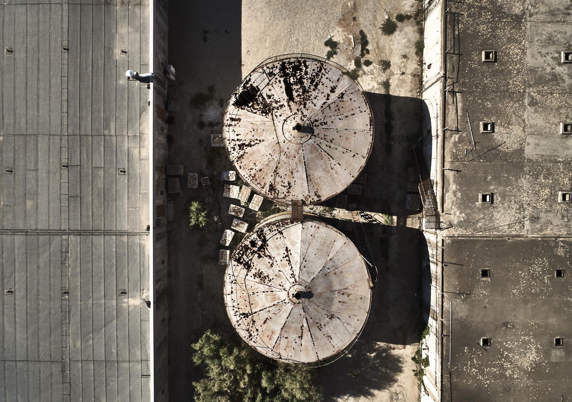Aerial view of repurposed concrete wine tanks transformed into stylish guest rooms for a unique holiday experience.