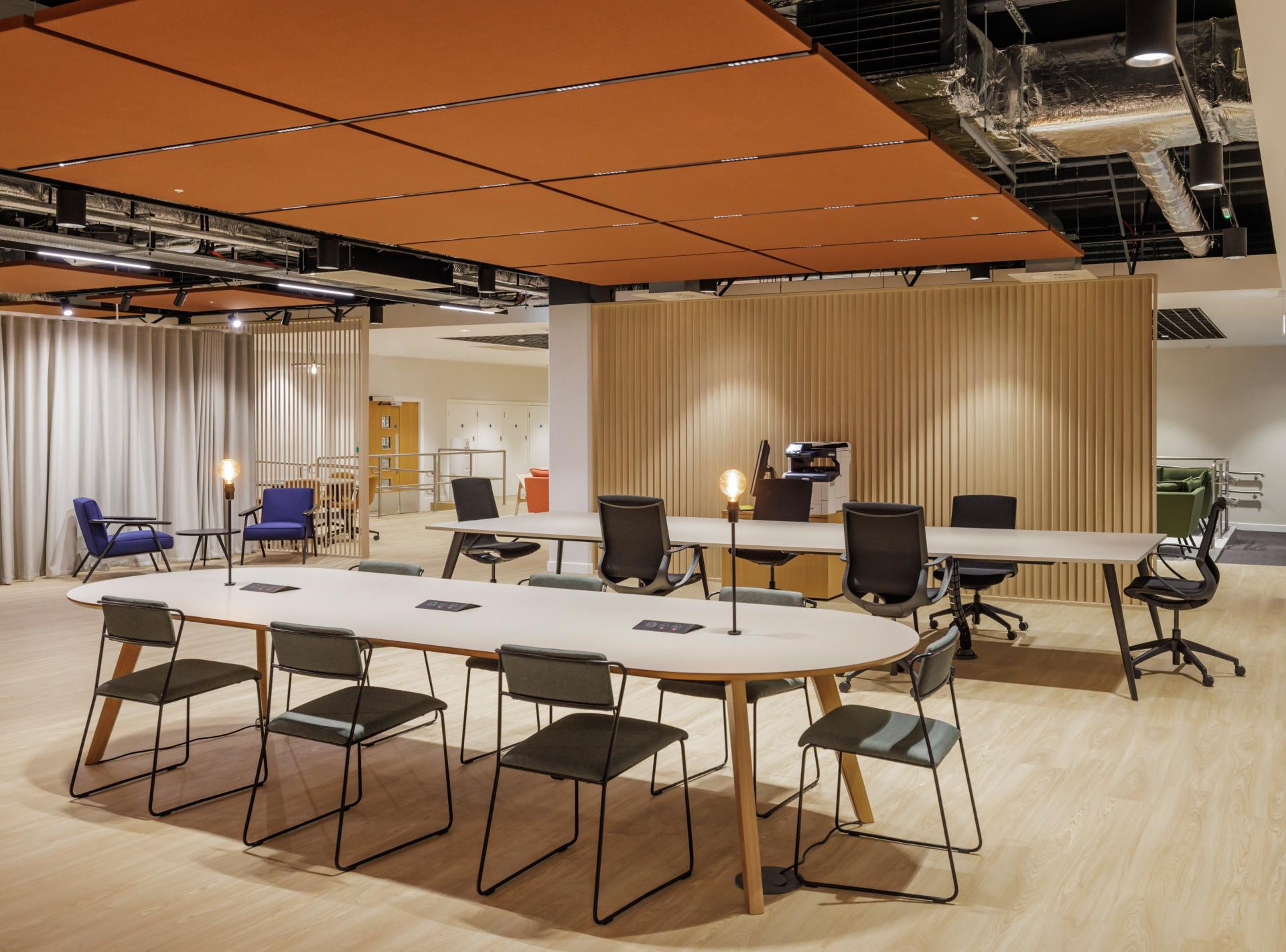 Modern office interior featuring sleek furniture, collaborative workspace, and warm lighting, showcasing SpaceInvader’s design approach.