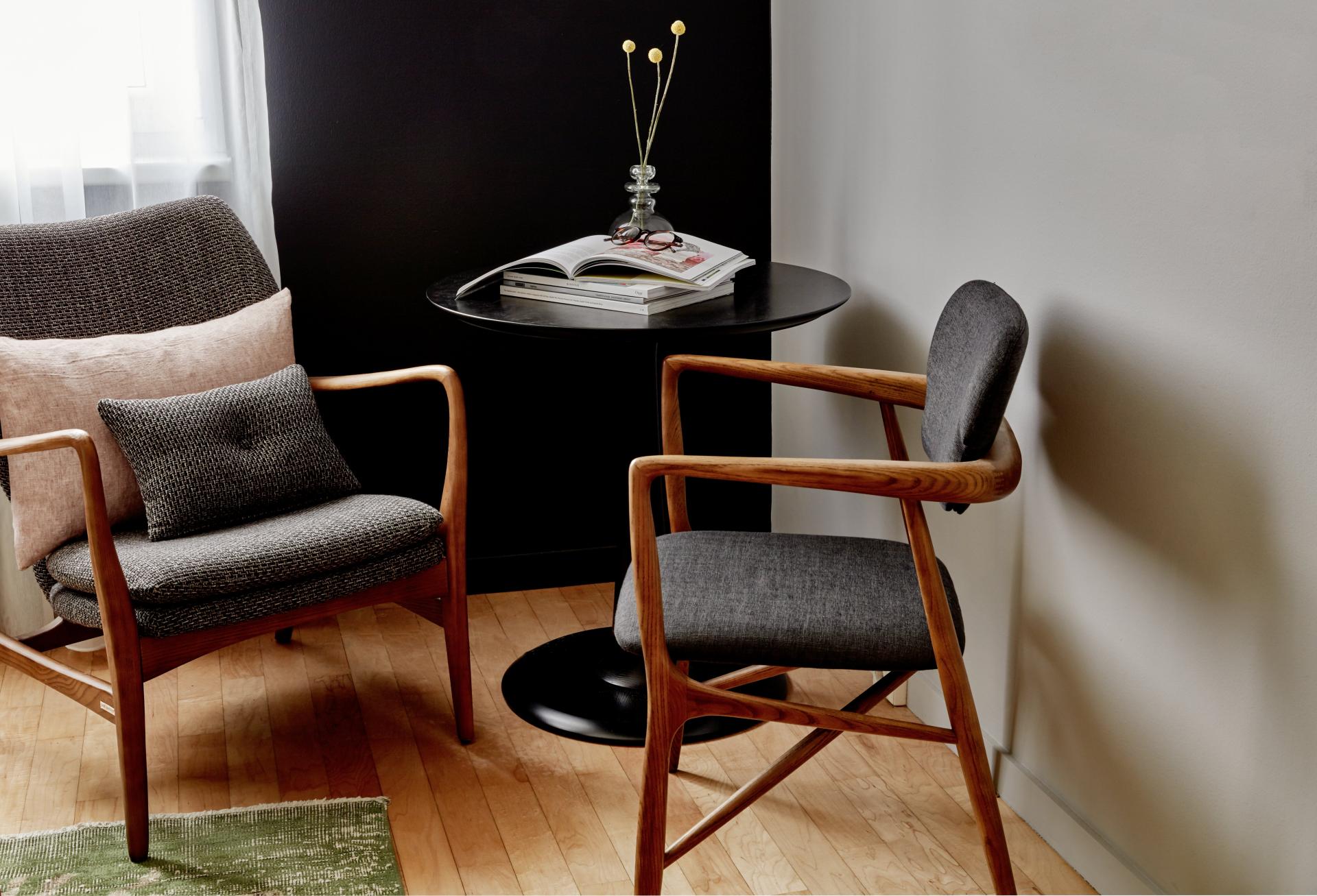 Stylish seating area in Max Brown Hotel with wooden chairs, cushions, and a minimalist table setting in a cozy vibe.