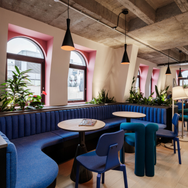 Vibrant co-working space at Huckletree Kensington featuring colorful seating, plants, and contemporary design elements.