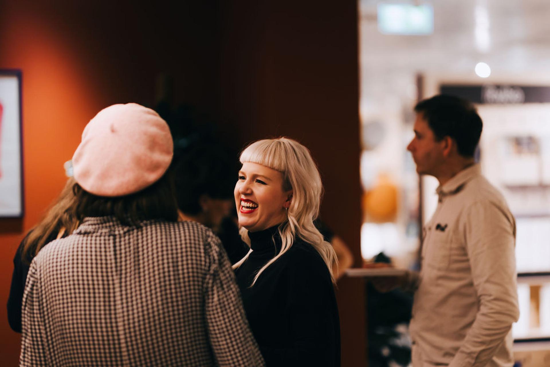 People engaging in conversation at a sustainability event, showcasing community involvement in discussions on biomaterials.