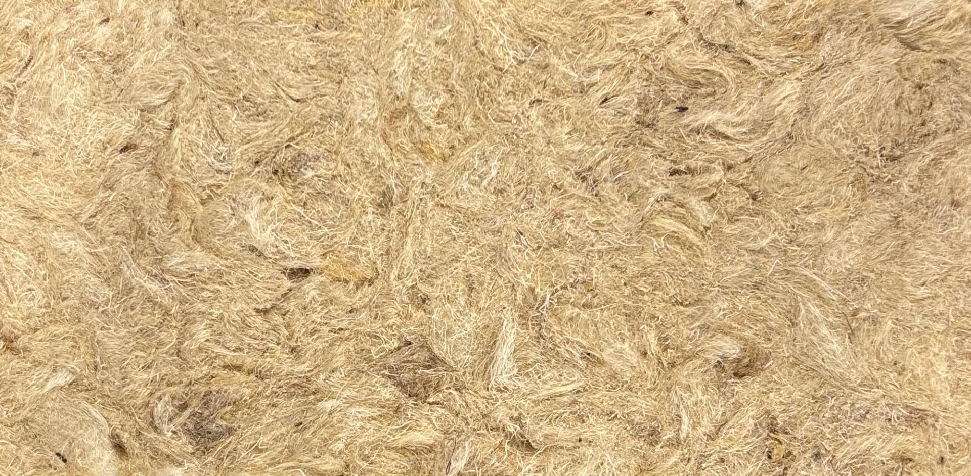 Natural fibers forming a textured surface, representing sustainable biomaterials and waste-based products for eco-friendly construction.