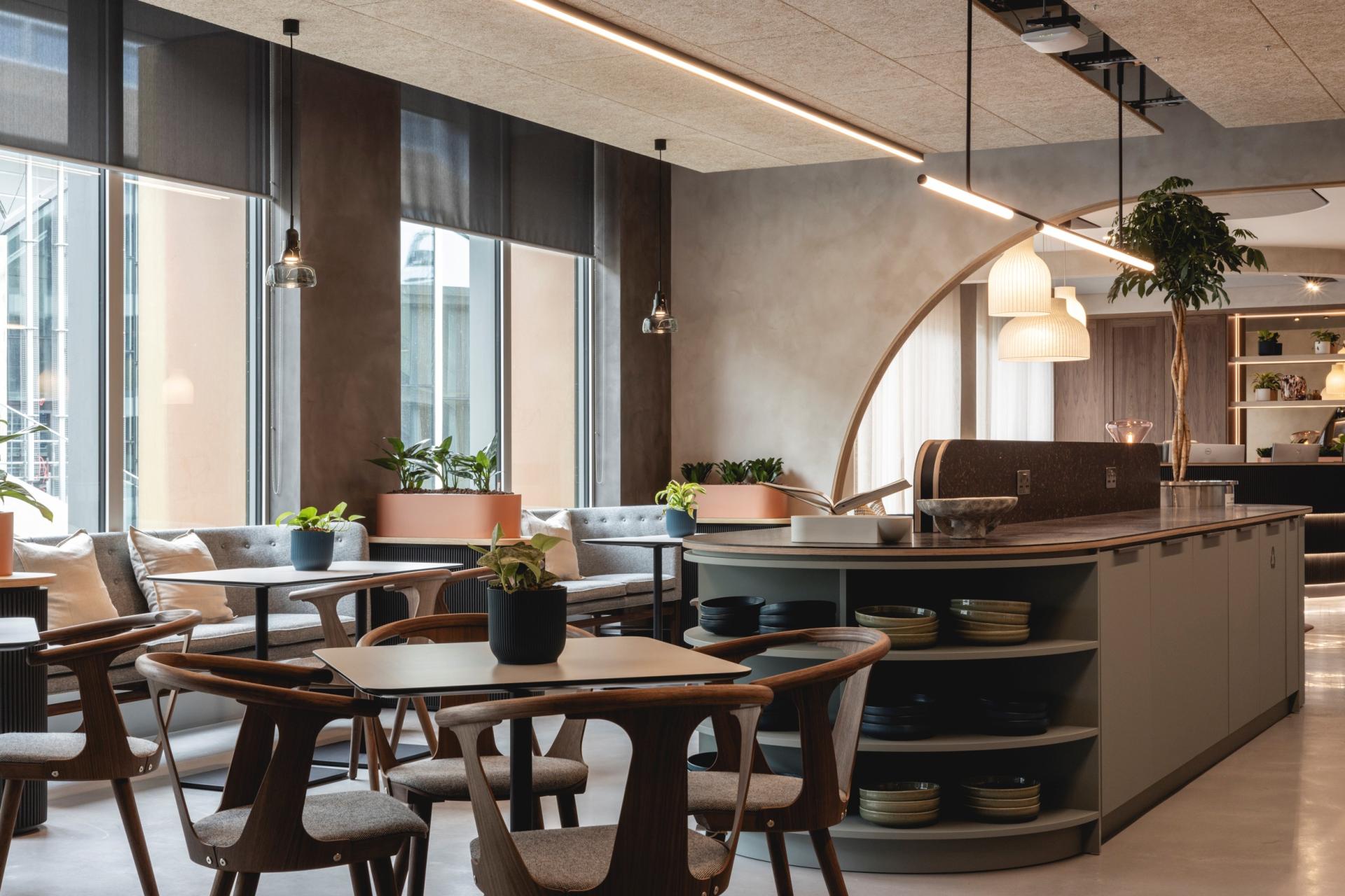 Modern workspace featuring Art Deco curves, comfortable seating, and greenery, designed by Ekho Studio for a calming ambience.