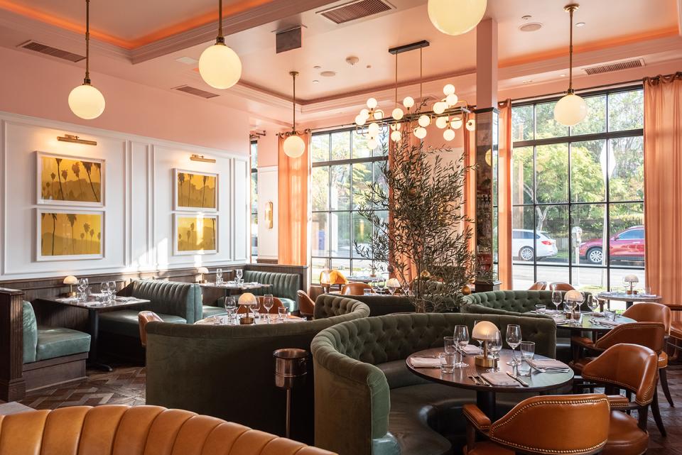 Elegant brasserie interior featuring plush seating, artistic decor, and large windows for natural light, designed by Fettle.