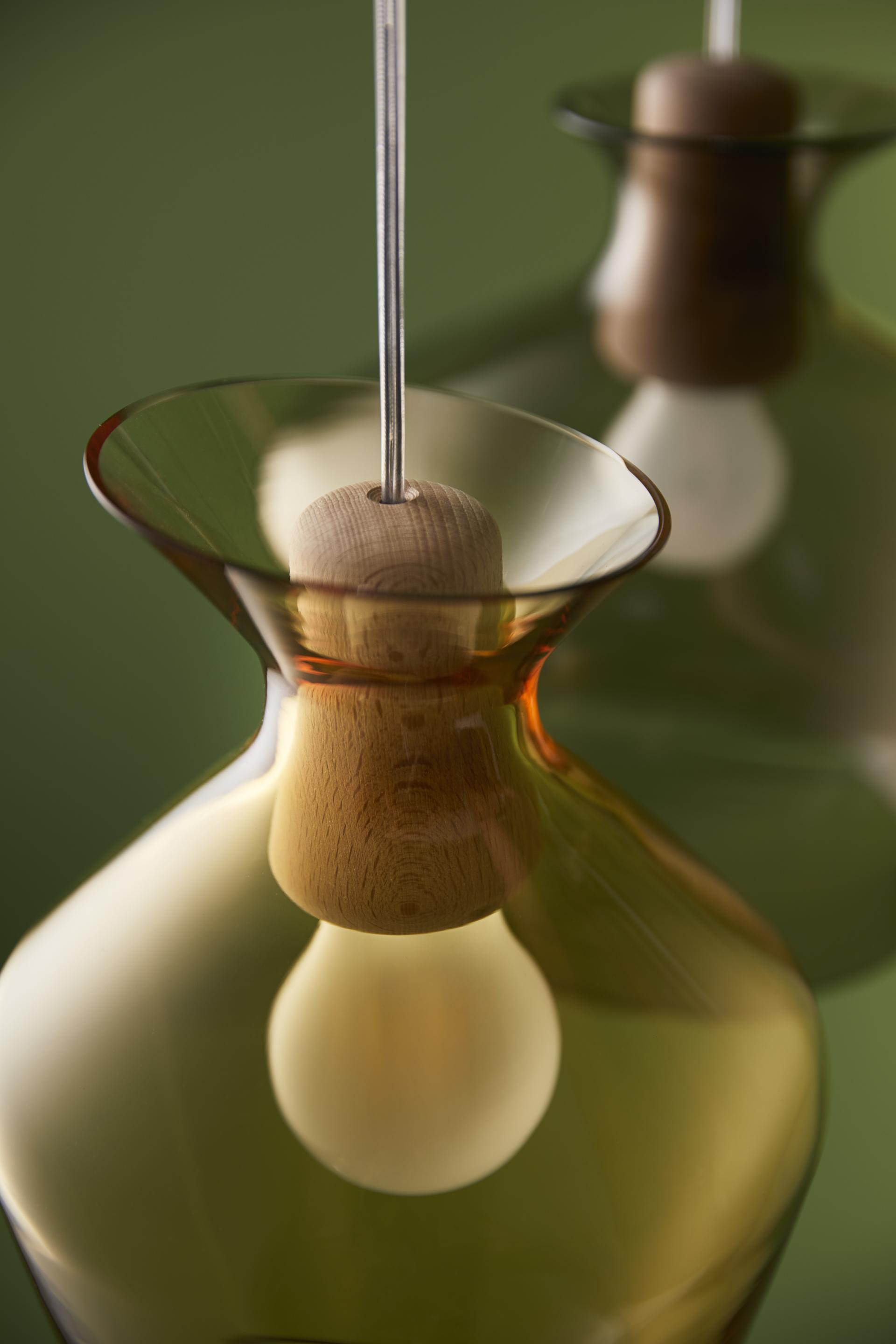 Elegant Malvasia lamp by Fabbian featuring rounded glass and wooden accents, showcasing modern design and craftsmanship.