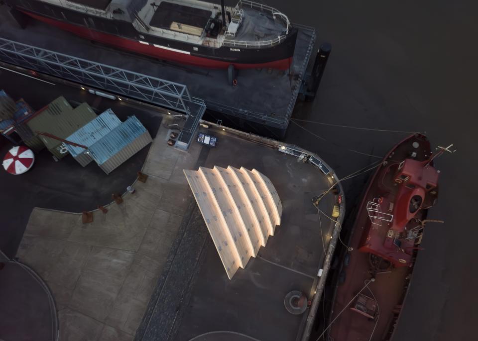 Experimental eucalyptus CLT pavilion, The Armadillo, prominently positioned at a waterfront location alongside moored boats.