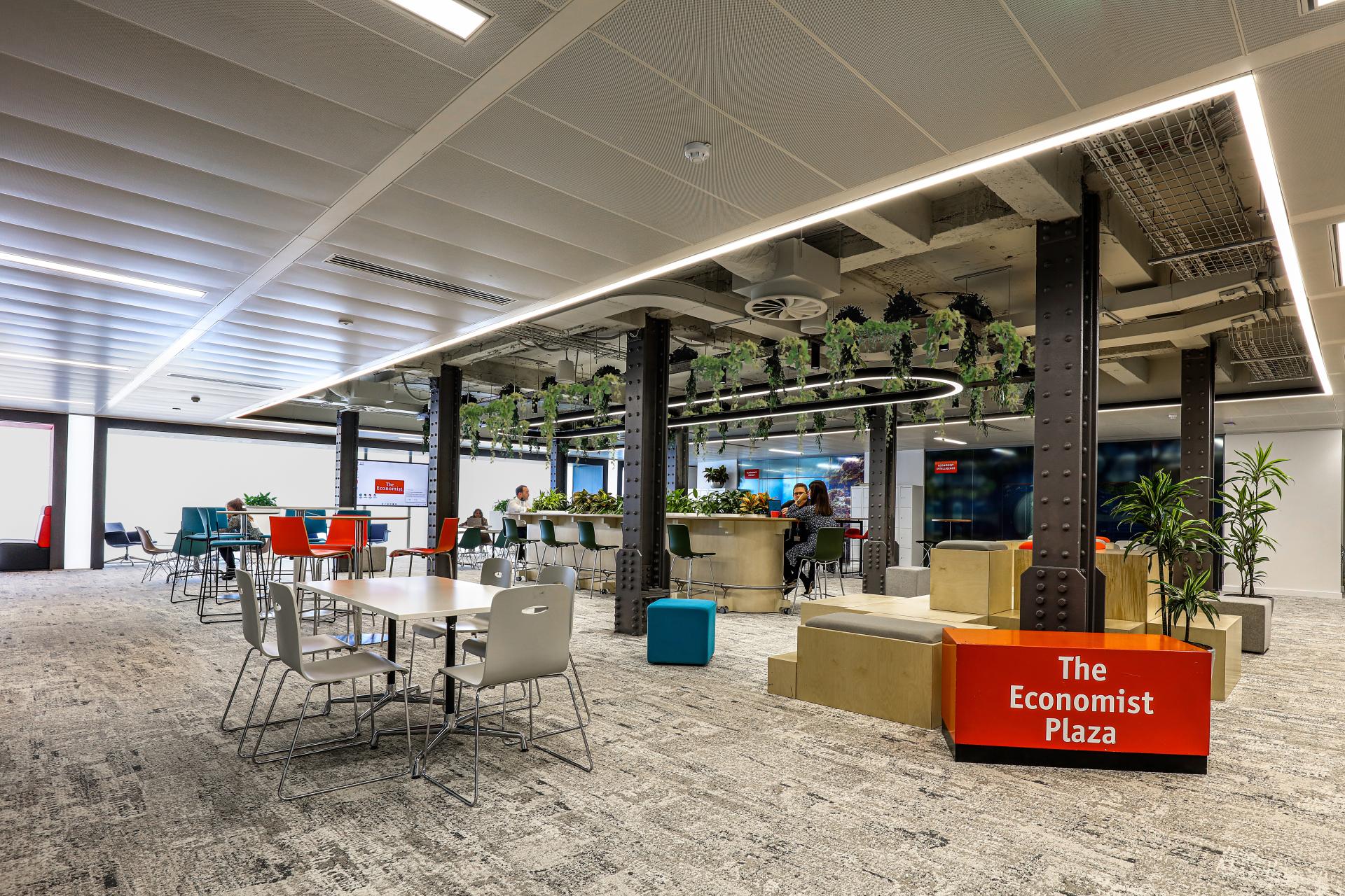 Modern office space in The Economist Group's Adelphi Building, featuring collaborative seating, greenery, and sustainable design elements.