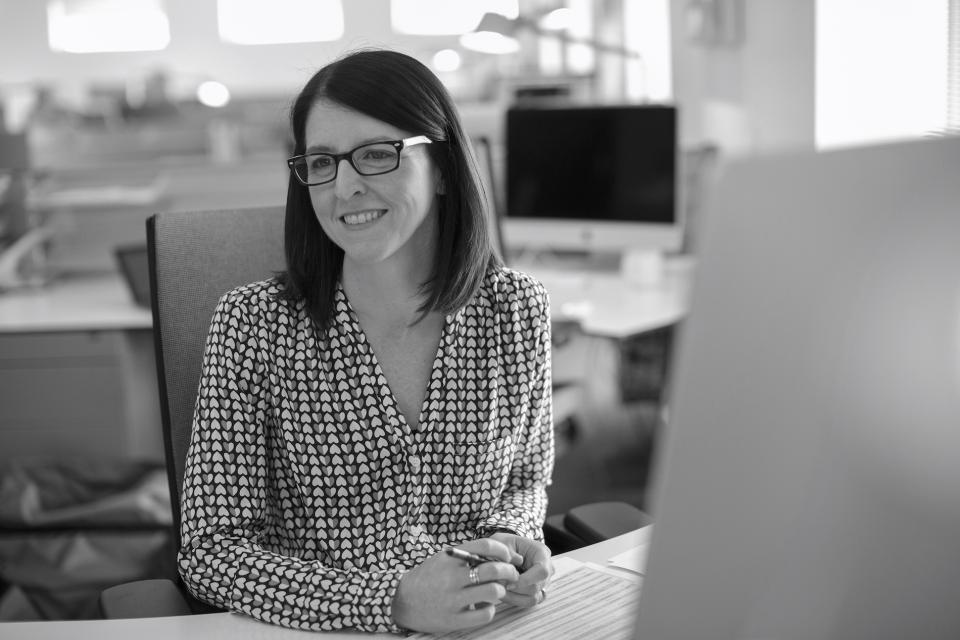 Gaynor Taylor from Mansfield Monk smiling at her desk, highlighting insights on workplace trends and future developments.