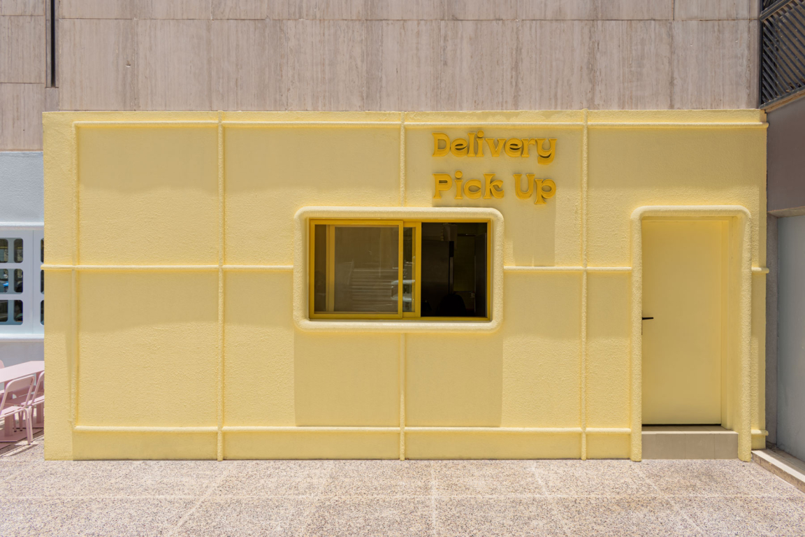 Bright yellow exterior of the Novu Waffle house featuring a