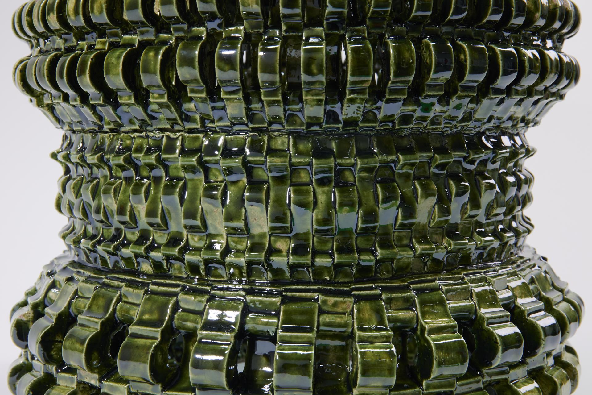 Textured green ceramic sculpture by Freyja Dorren, showcasing her intricate textile design influence and craftsmanship.