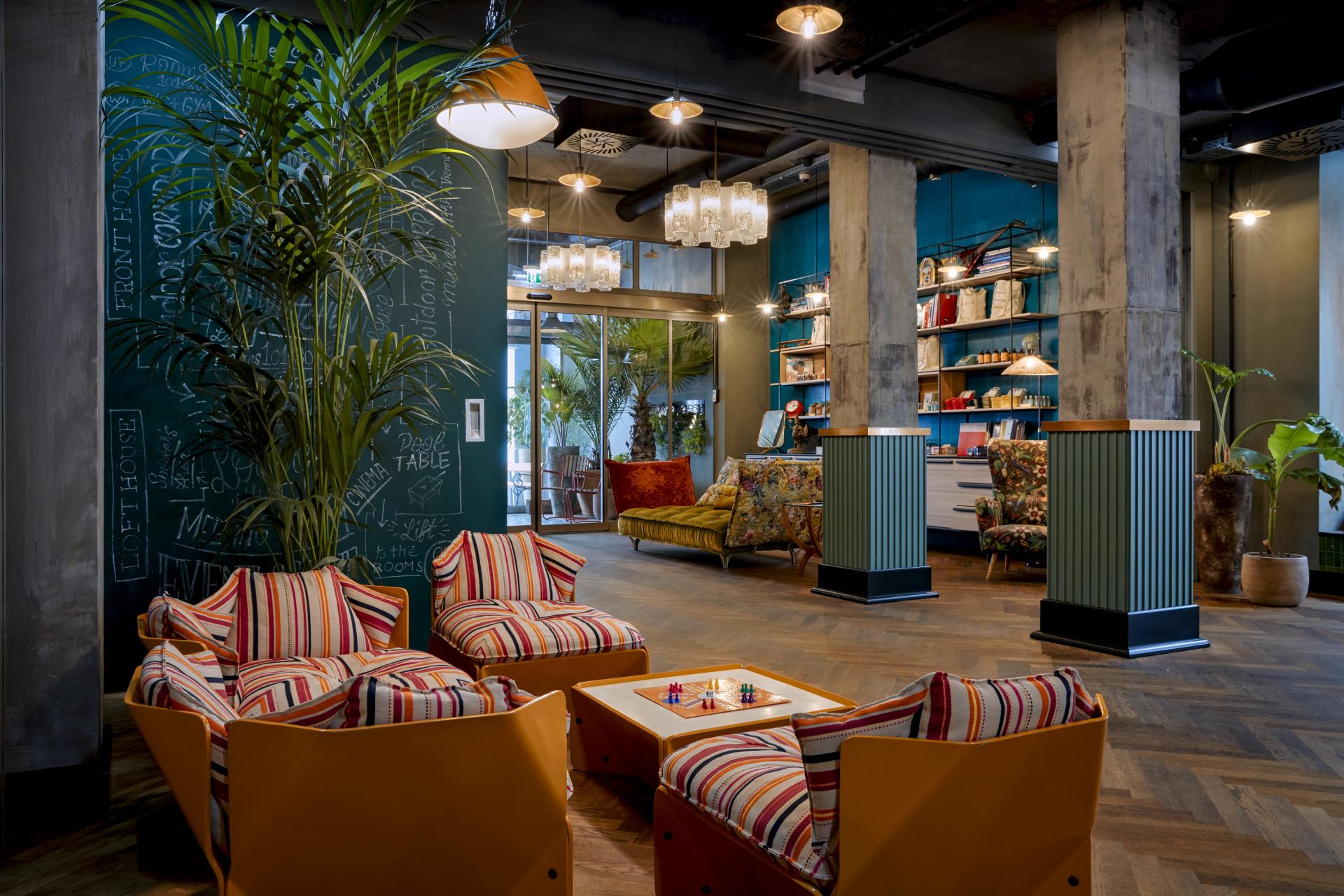 Cozy lobby area at Max Brown Hotel in Vienna, featuring stylish seating, plants, and creative decor elements.