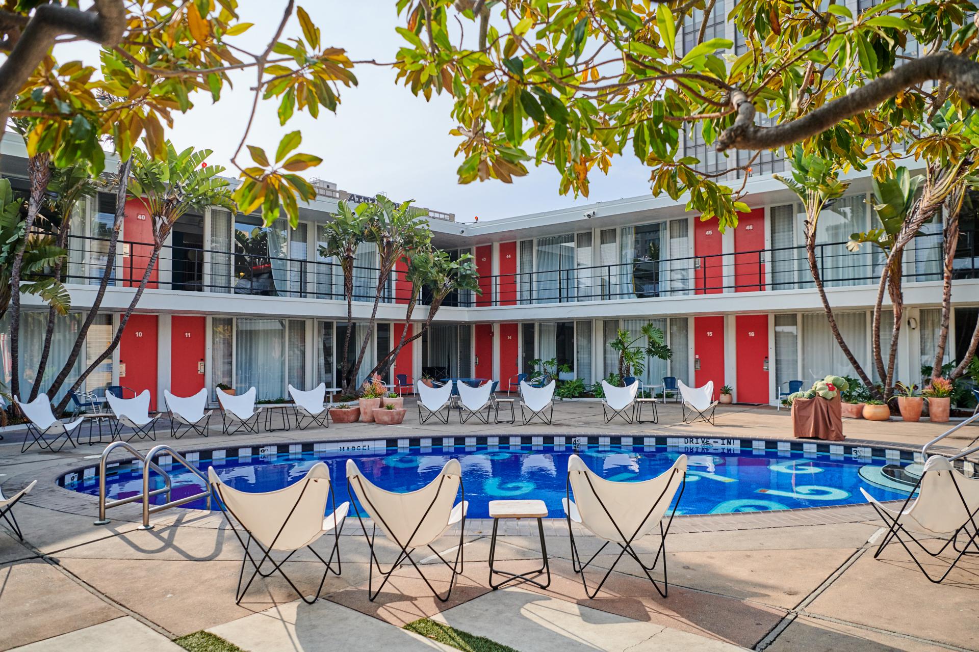 Bright pool area of the Phoenix Hotel, featuring stylish seating and lush tropical landscaping in San Francisco's Tenderloin neighborhood.