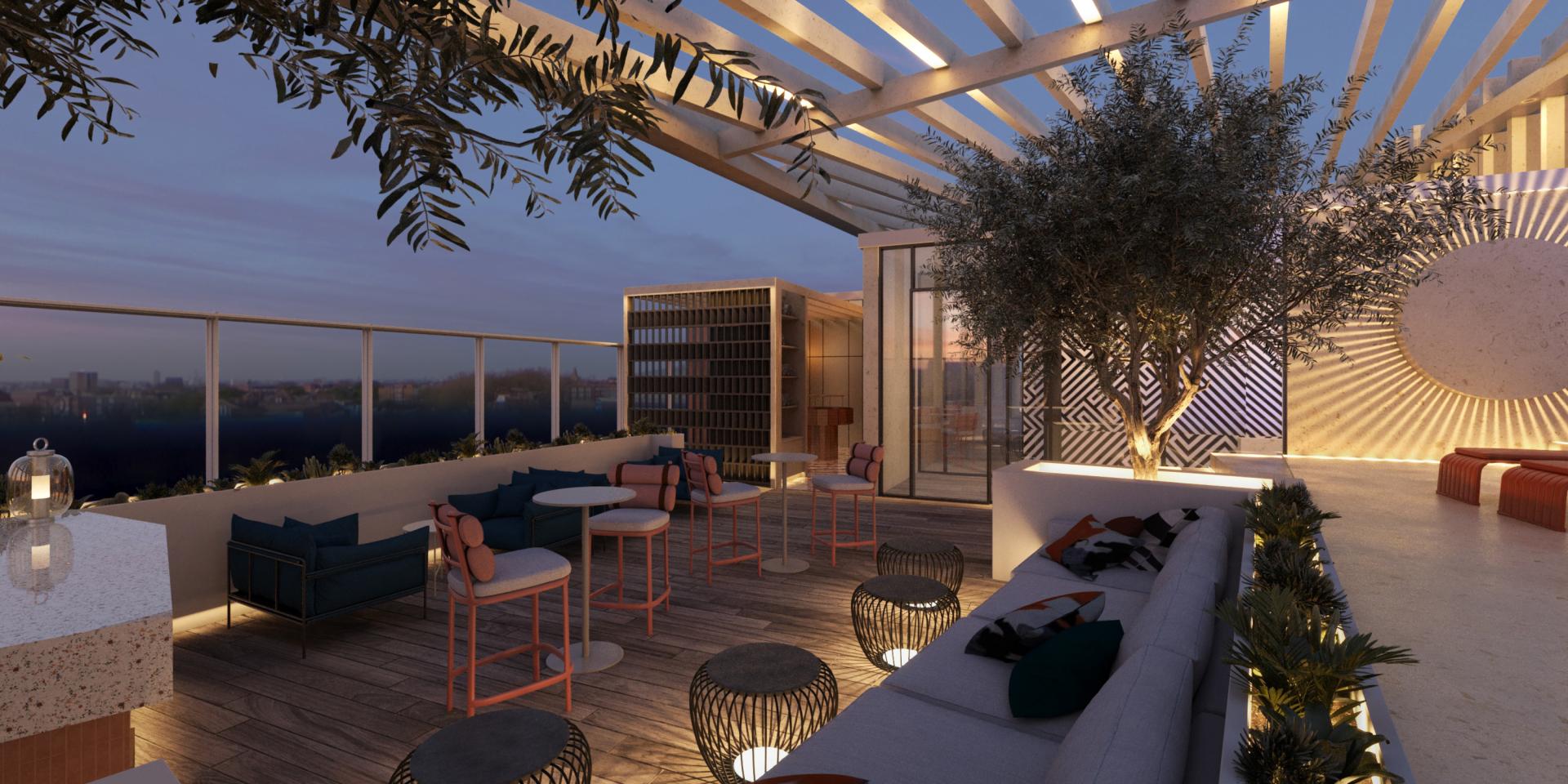 Rooftop lounge area of Malta's Tribe hotel featuring modern seating, greenery, and stylish decor against a sunset backdrop.