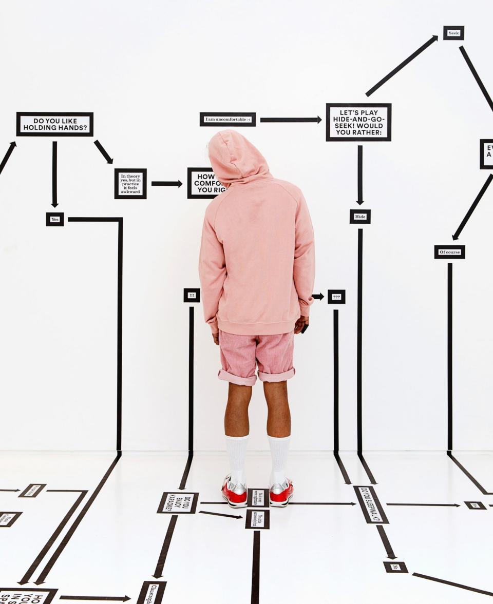 Visitor engaging with a colorful interactive flowchart at Color Factory in New York City, exploring personal questions and choices.