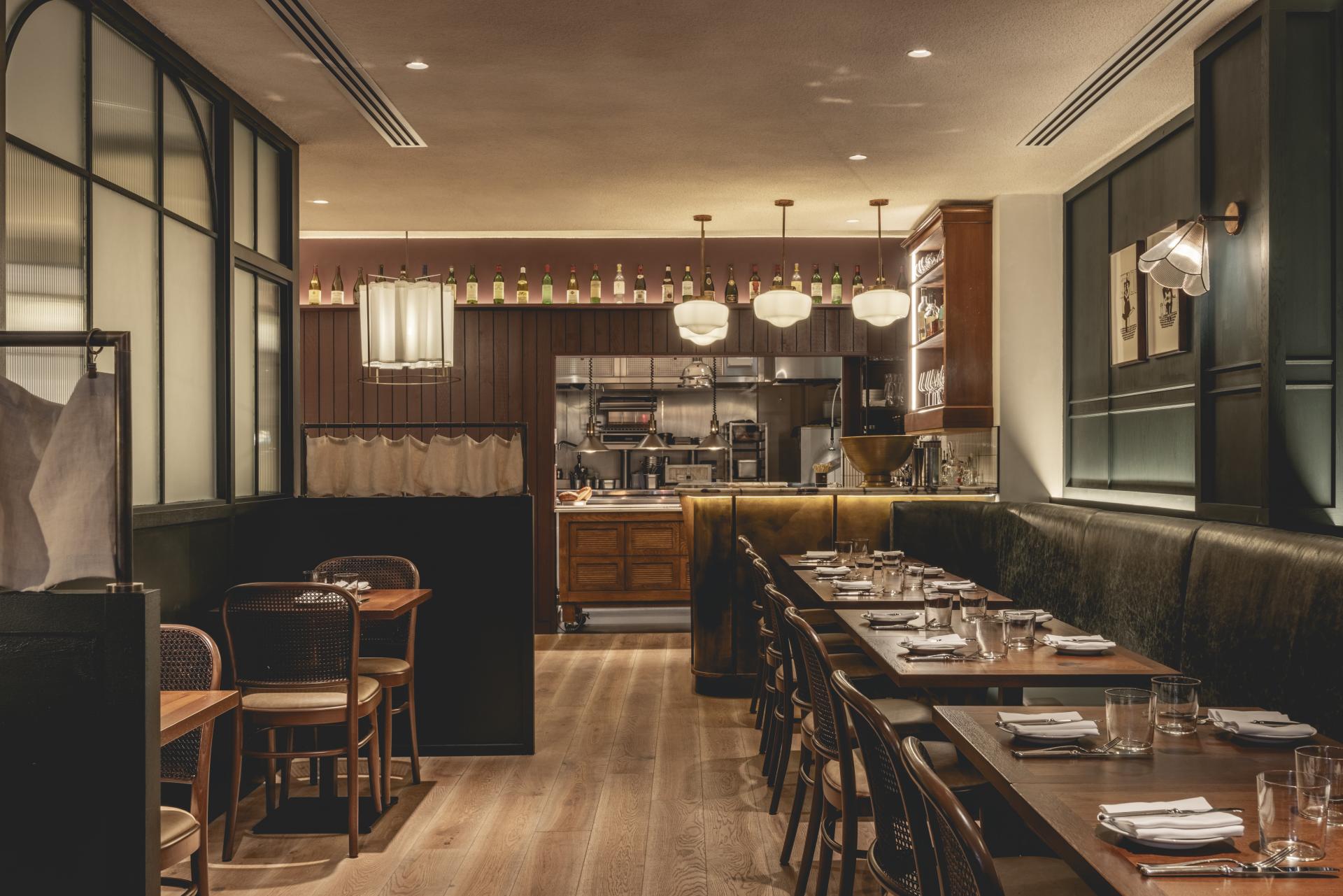 Elegant dining area of Fitzrovia restaurant, blending Parisian bistro style with rustic British decor and modern lighting.