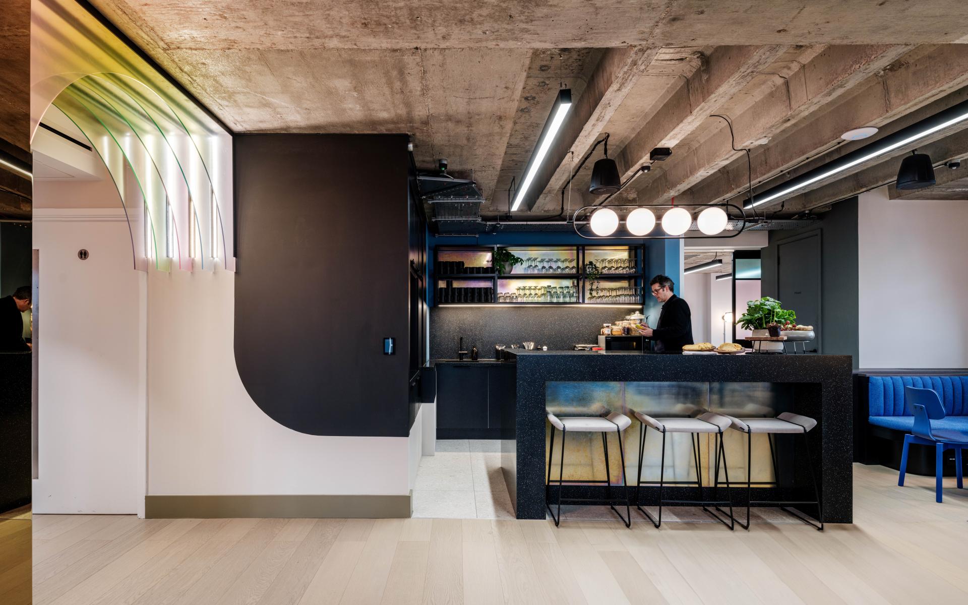 Modern co-working kitchen at Huckletree Kensington, featuring sleek design, vibrant hues, and sustainable decor elements.