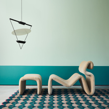 Whimsical furniture and a patterned rug create a playful design scene reflecting Indonesian and Colombian influences.