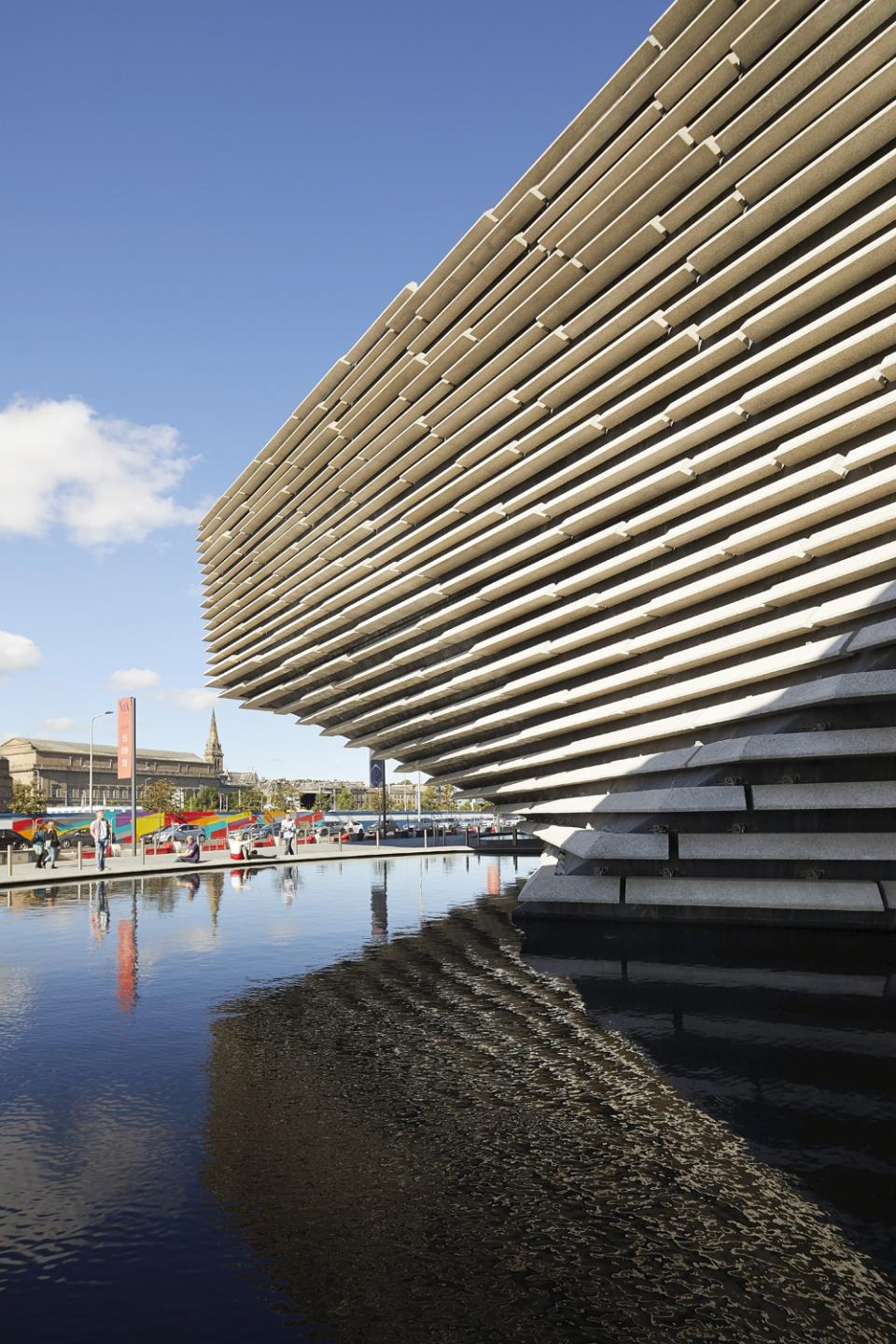 Striking exterior of V&A Dundee designed by Kengo Kuma, showcasing layered architecture reflecting on the water.